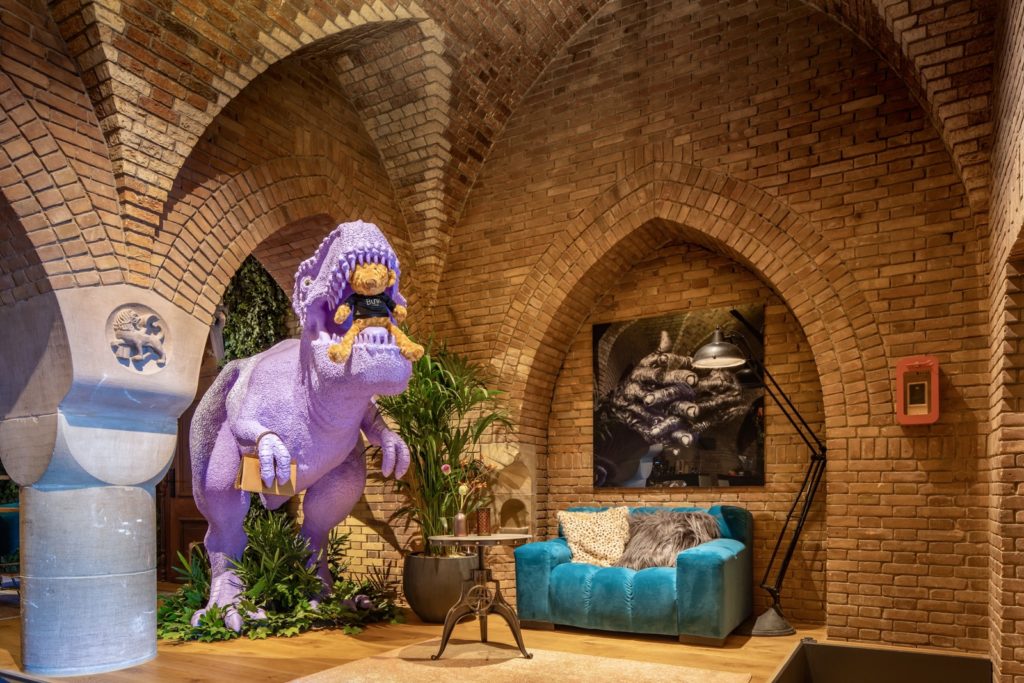 Bunk Amsterdam — purple dinosaur beneath the original church arches